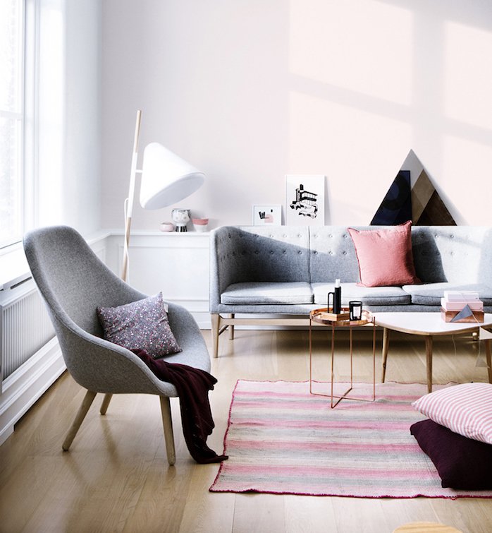 salón decorado en tonos pastel, muebles de diseño en gris marengo, paredes en rosado, suelo de parquet 