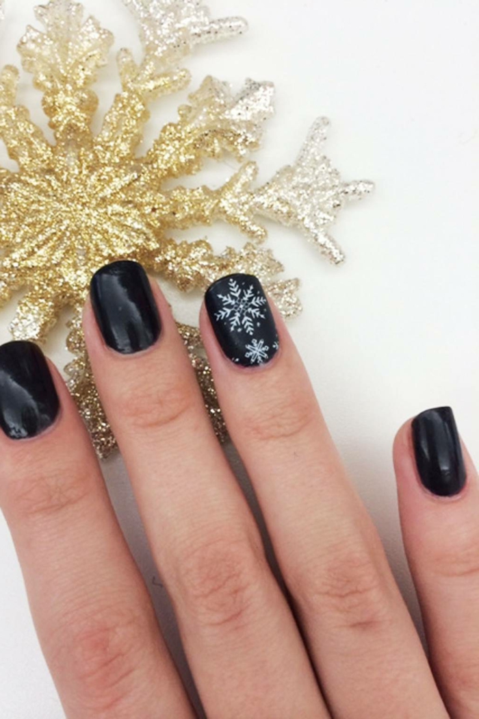 diseños de uñas en blanco y negro para navidad, uñas cortas pintadas en negro con dibujos de copos de nieve 
