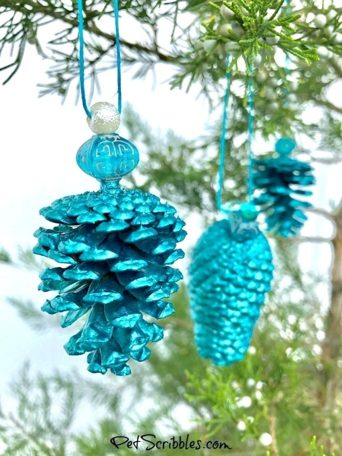 ideas sobre cómo decorar un arbol de navidad casero, piñas pintadas en azul brillante, ornamentos navideños DIY 