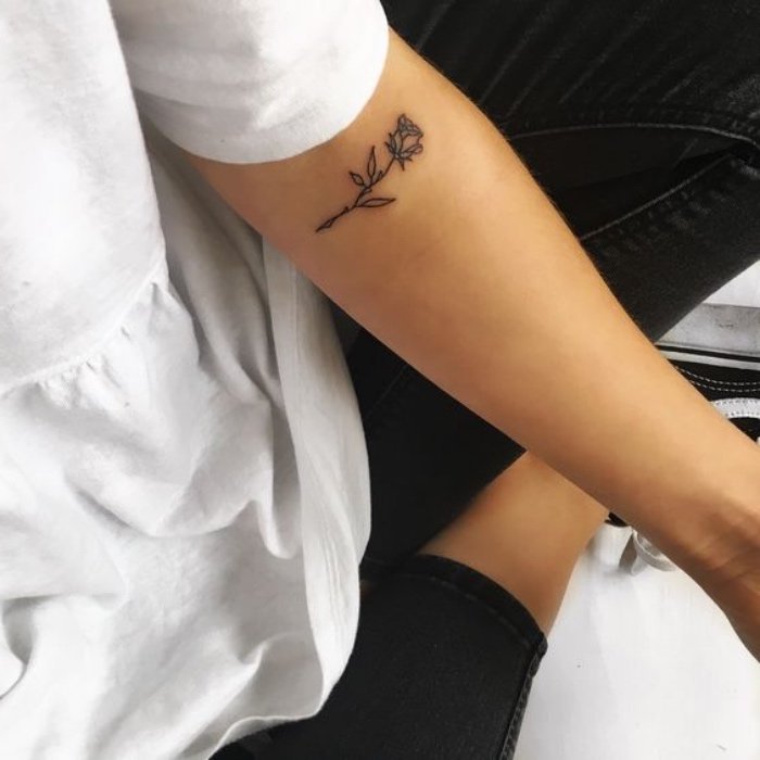 pequeña rosa tatuada en el antebrazo, diseños de tatuajes de flores con alto significado 