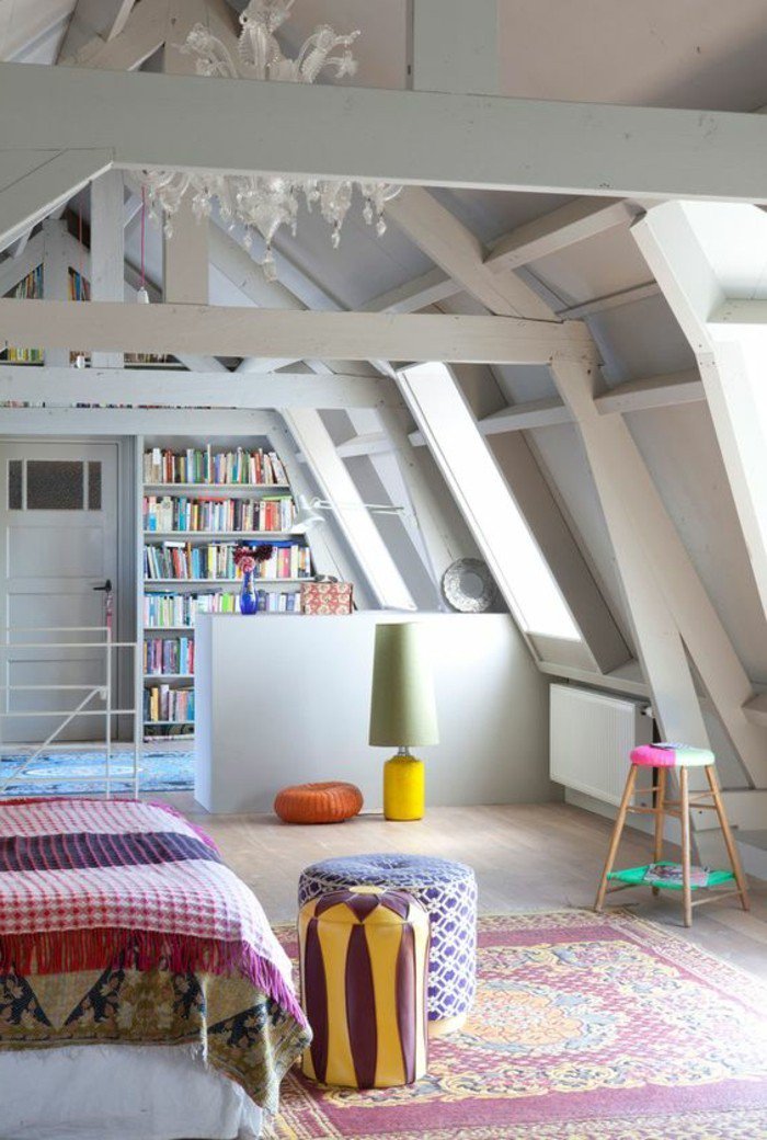 espacio abuhardillado, techo con vigas, decoracion salon pequeño en gris, estantería con libros 