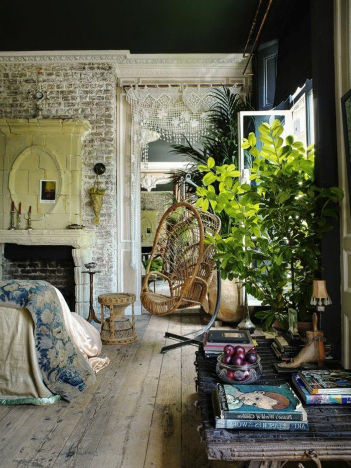 decoración salón pequeño con muebles vintage, chimenea de leña, pared de ladrillo y plantas verdes 