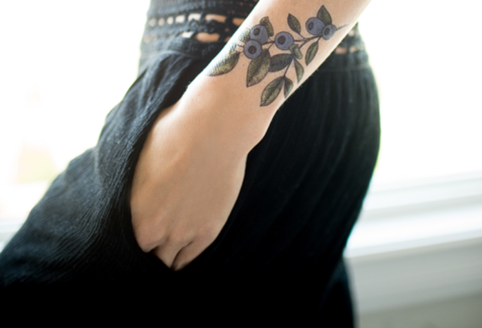 adorable tatuaje en el antebrazo, diseños de tatuajes con motivos florales, significado de las flores