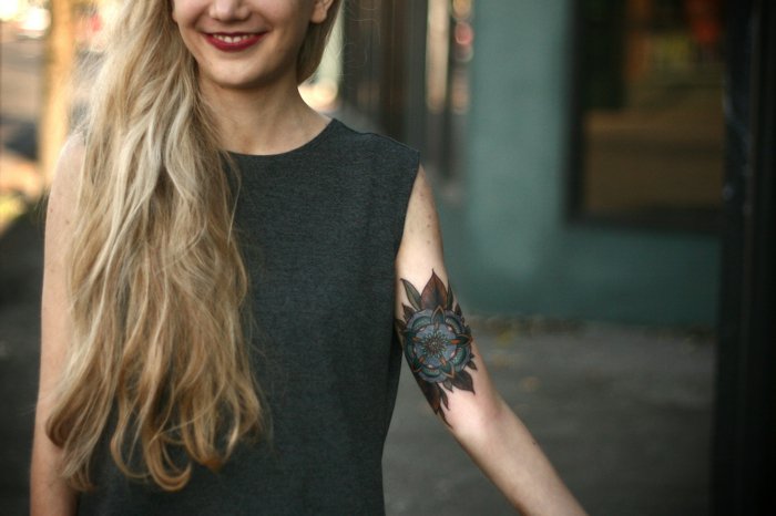 tatuaje en el brazo super original con grande flor en colores oscuros, tatuajes de flores 