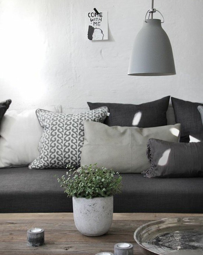 salon gris y blanco decorado en estilo escandinavo y decoración minimalista, sofá en gris oscuro, cojines decorativos 
