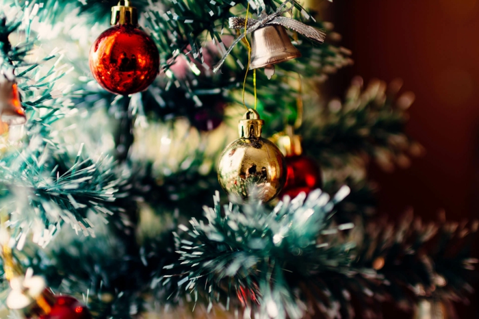 árbol navideño artificial con efecto de nevado adornado de preciosas bolas de navidad en rojo y dorado 