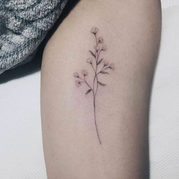 pequeños detalles tatuados en el brazo, tatuaje flor de loto, precioso detalle en estilo minimalista 