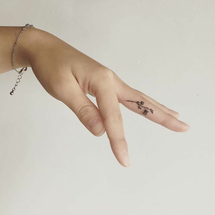 adorables propuestas tatuajes de flores minimalistas, tattoos pequeños para mujeres en el dedo 
