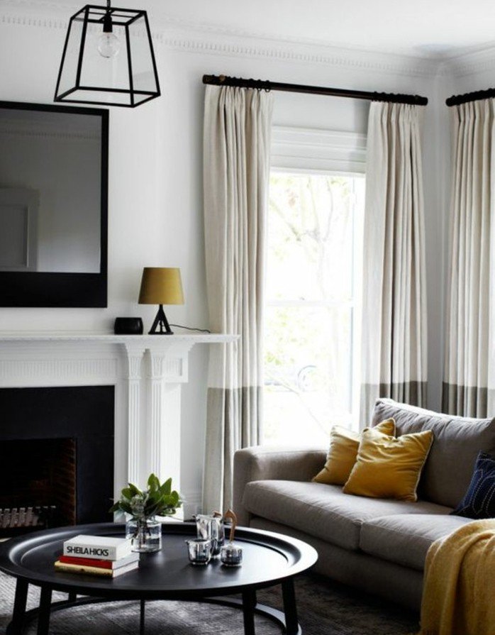 salones grises de diseño con detalles en blanco beige, lámpara moderna en negro y detalles en color mostaza 