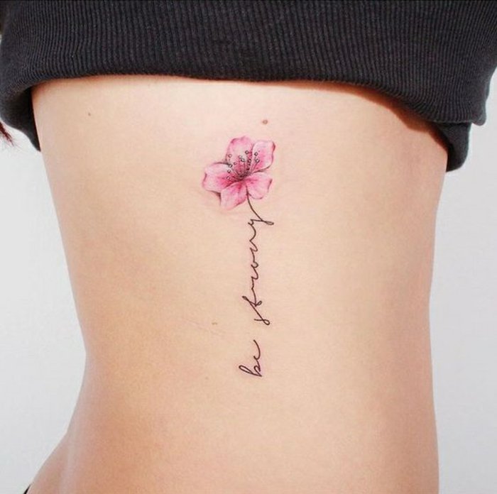 unas de las mejores propuestas de tatuajes con flores para mujeres, bonita flor en rosado, tattoo con letras 