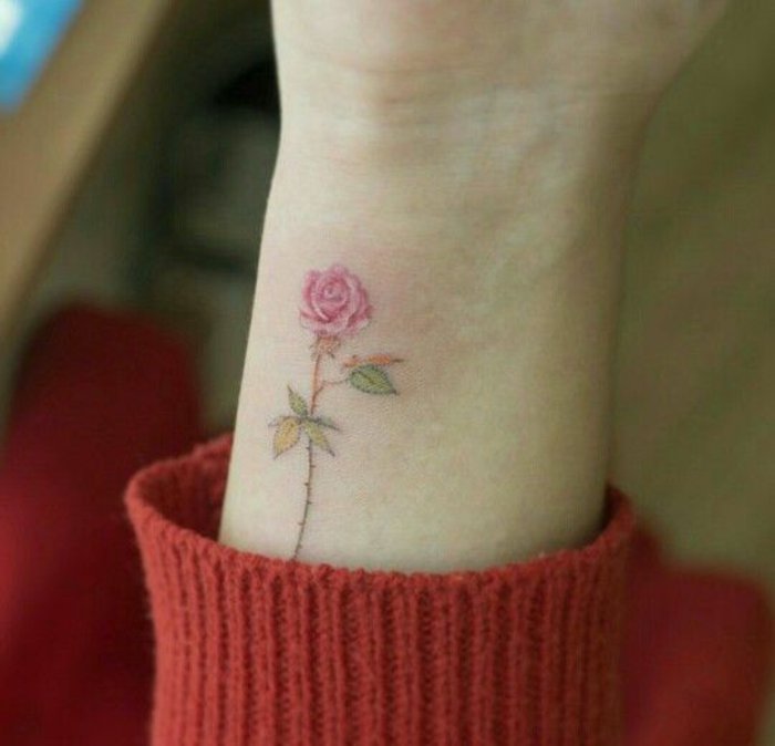 pequeño detalle en color rosa en la muñeca, tattoos femininos con flores en imagines 