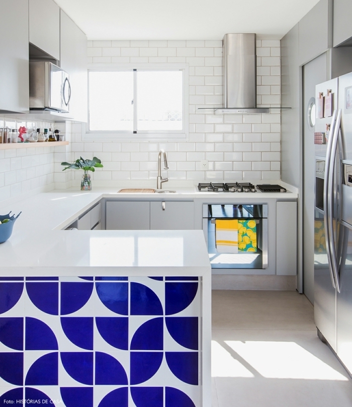 cocina americana pequeña decorada en blanco con bonita isla azulejos blanco y azul, azulejos blancos en las paredes 
