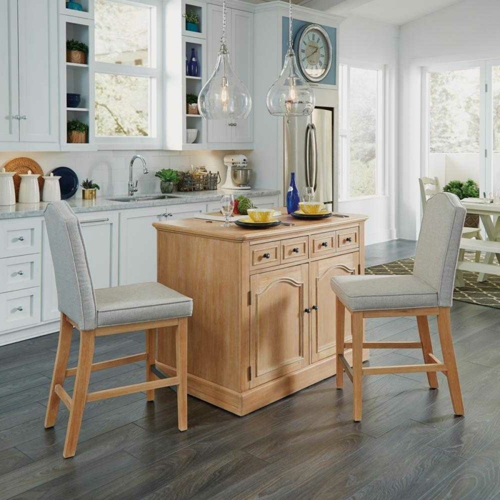 cocina decorada en blanco con muebles de madera, suelo de parquet y lámparas de diseño moderno 