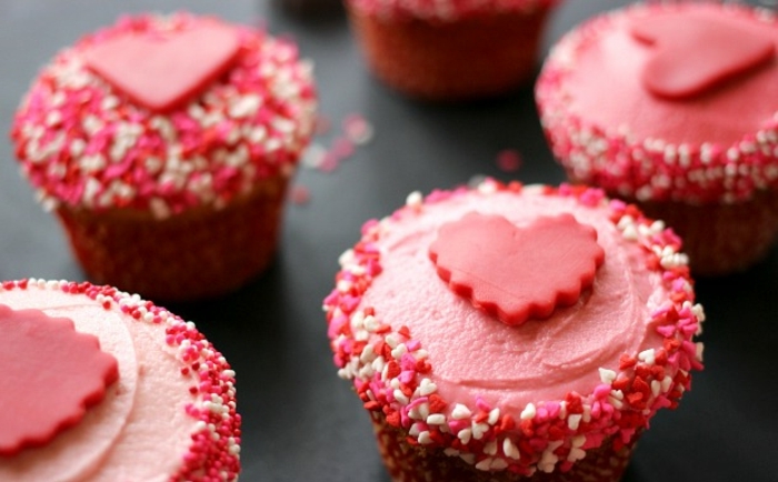 magdalenas super ricas en color rosado decoradas con corazones de azúcar, ideas de recetas de cenas faciles