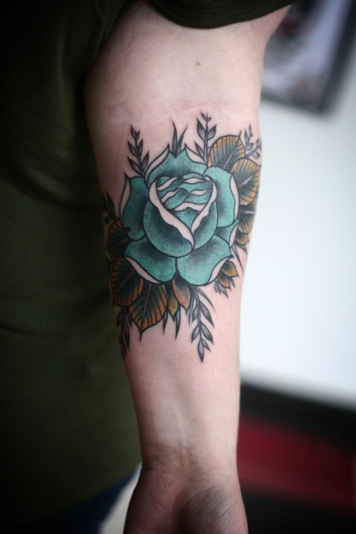 ideas de tatuajes brazo con flores y rosas para hombres, grande rosa en color verde tatuada en el antebrazo 