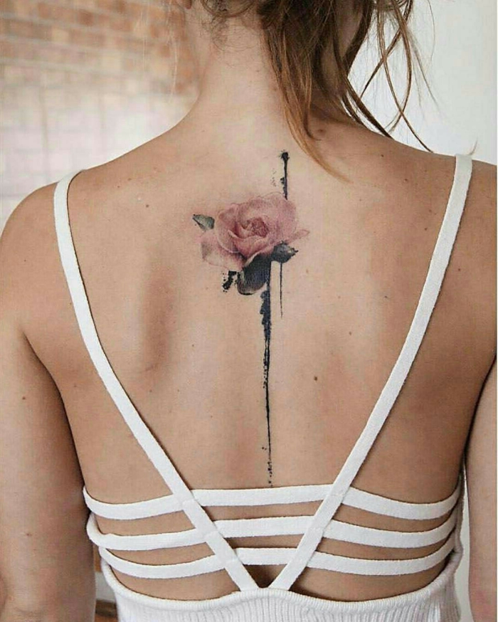 fotos de tatuajes espalda mujer, bonita rosa con pintura acuarela tatuada en la espina dorsal 