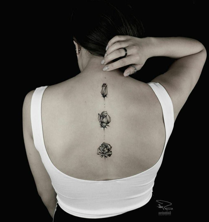 ejemplo de tatuajes espalda mujer, tres bonitas rosas tatuadas en la espalda con tinta negra 