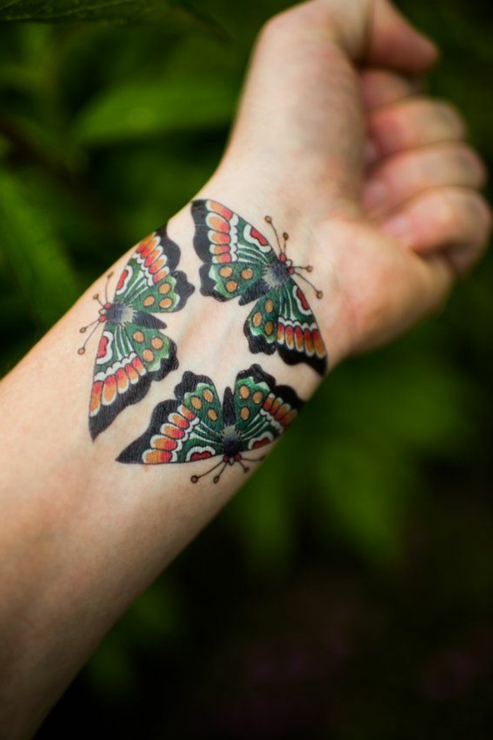 ejemplos de tatuajes en la muñeca con mariposas, tattoo colorido con mariposas en estilo old school 