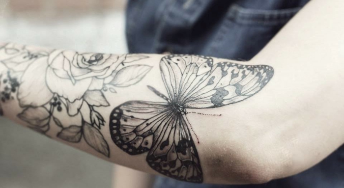 fotos de tatuajes en el antebrazo con mariposa y flores, mariposa negra y rosas tatuadas en el antebrazo 
