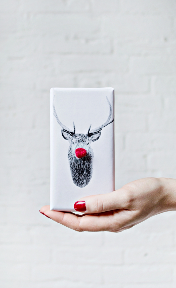 embalaje DIy con sellos de reno y pompones en color rojo, fotos sobre envolver regalos de forma original