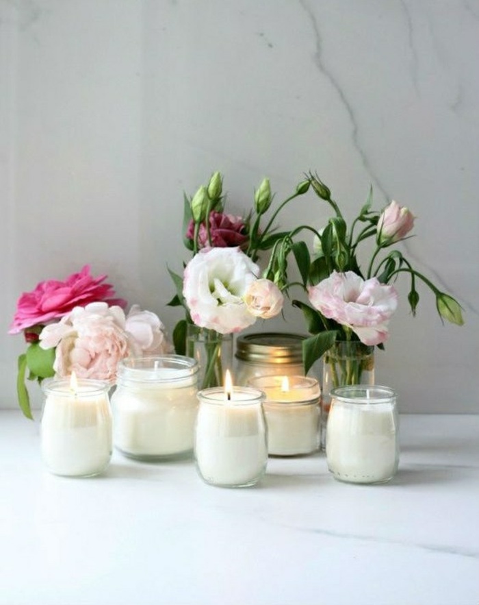centro de mesa decorativo hecho a mano, frascos de vidrio de diferente forma con velas y flores 