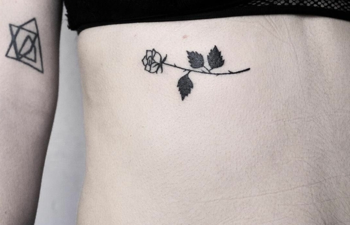 tatuajes con rosas de diseño original, rosa horizontal tatuada en las costillas, tattoos tinta negra 