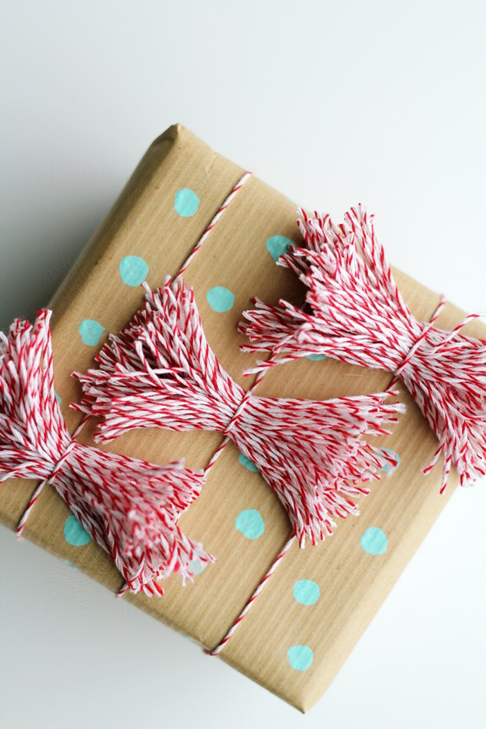 decoración regalo con papel craft y lazos de hilo en blanco y rojo, ideas originales sobre como envolver un regalo 