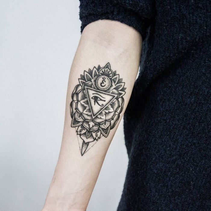 bonito y complejo diseño de tattoo geometrico con triángulos y elementos florales, ejemplos de tattoo antebrazo mujer 