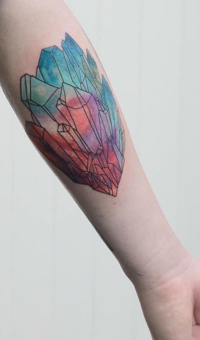 colorido tatuaje con acuarelas, tatuaje de cristales en el antebrazo, tattoo en azul y rojo 