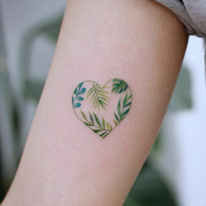 tattoo en el brazo de corazón pequeño con elementos botánicos, tatuajes para hacerse en pareja