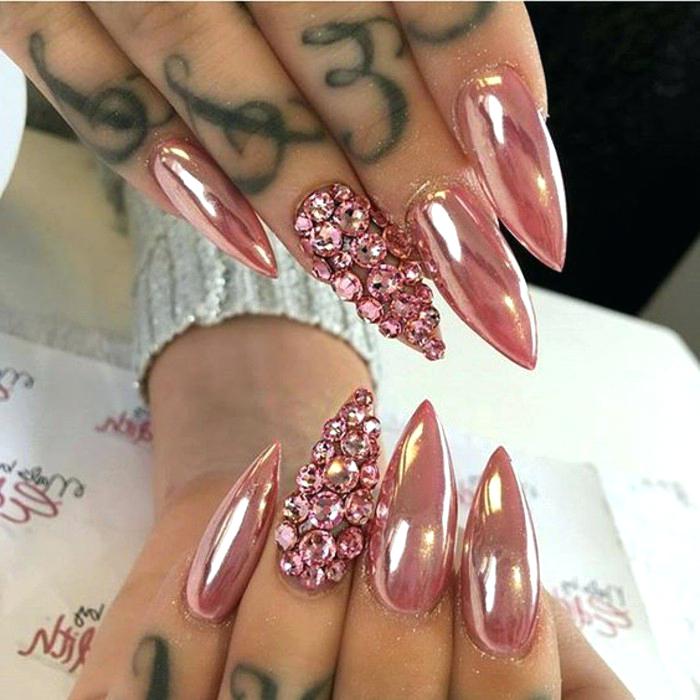 diseños de uñas exclusivos, uñas largas de forma stiletto pintadas en rosado metalizado, uñas decoradas con piedras