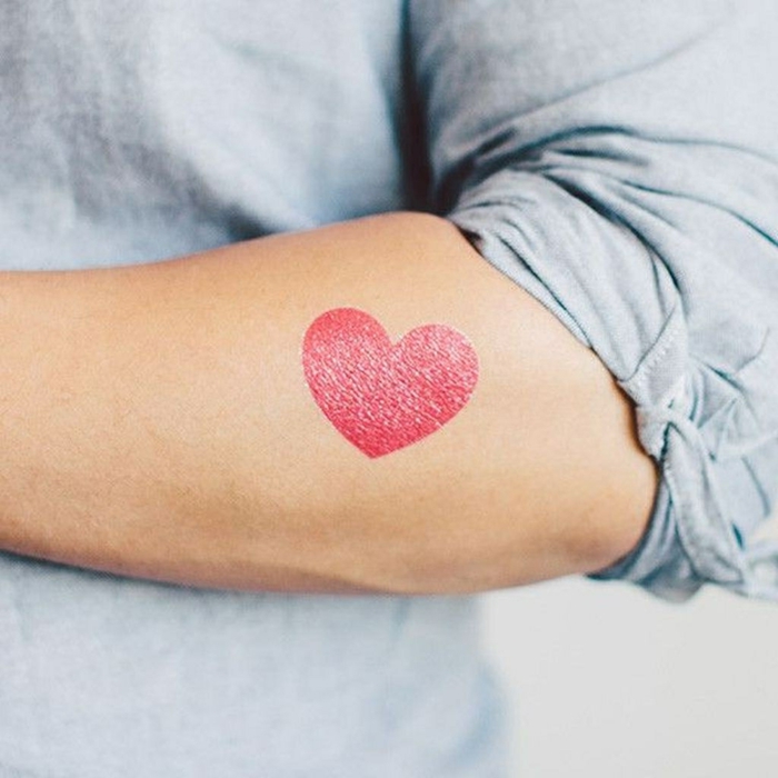 precioso tatuaje en el antebrazo en color rojo, diseños de corazon tattoo para hombres y mujeres 