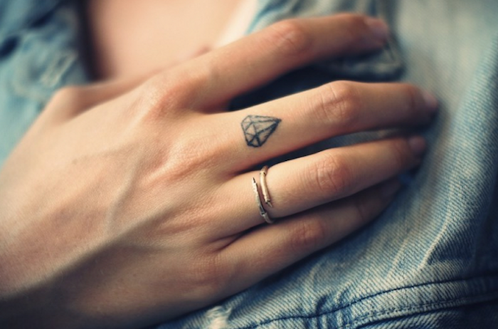 pequeño diamante tatuado en el dedo corazón, las mejores propuestas de tatuajes en los dedos de la mano 