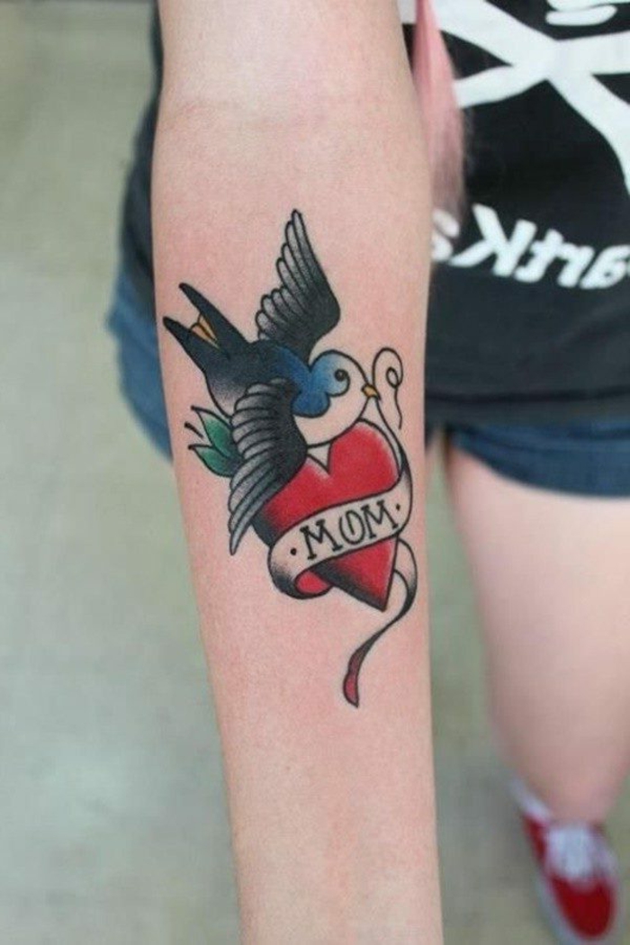 tatuaje old school en el antebrazo, tatuaje colorido con ave u corazón, diseños de tatuajes simbólicos y personales 