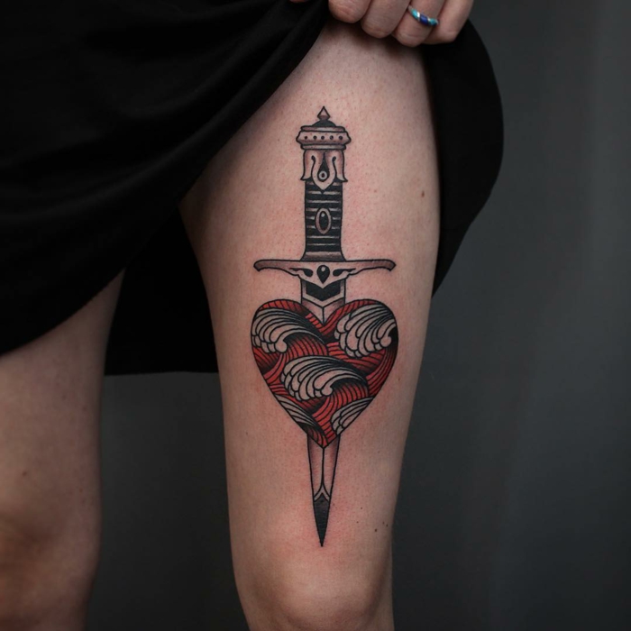 diseños de tatuaje corazón y sus significados, tatuaje corazón old school con espada en la pierna 