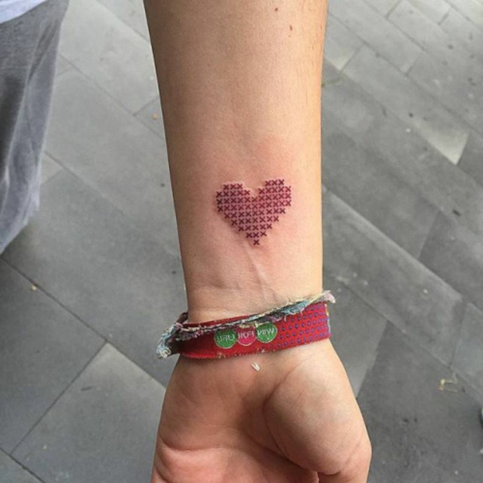 tatuajes para parejas, ideas de tatuajes corazon para hacerse en pareja, corazón original rojo tatuado en el antebrazo 