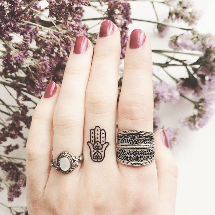 las mejores ideas de tatuajes pequeños para dedos, tattoo minimalista en el dedo corazón con significado