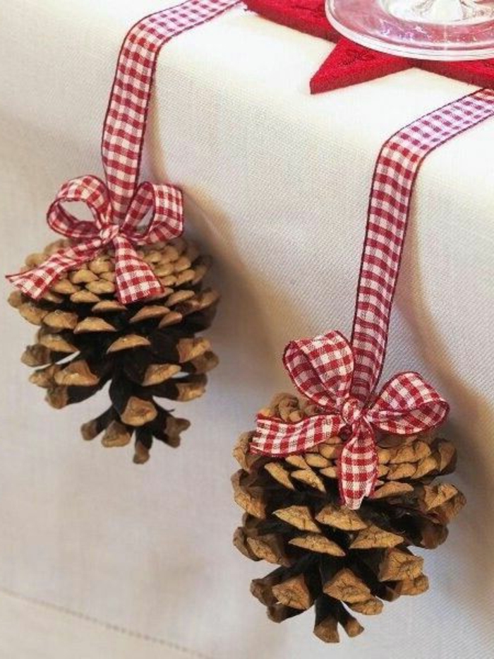 ideas simples y bonitas de decoracion mesas navidad, piñas adornadas con cintas en blanco y rojo 