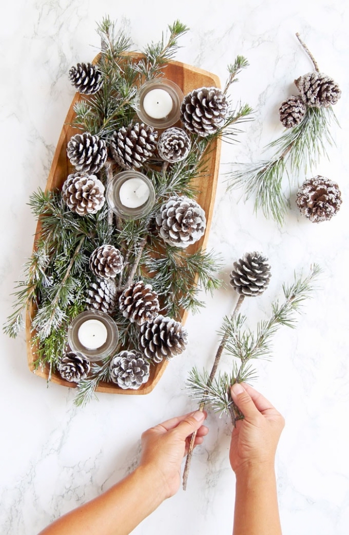 centro de mesa casero con ramos de pino y piñas pintadas en blanca, decoracion de mesa navideña