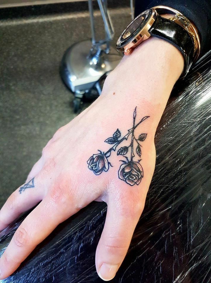 dos rosas cruzadas tatuadas en la mano, diseños de tatuajes originales, las mejores tatuajes en la mano 