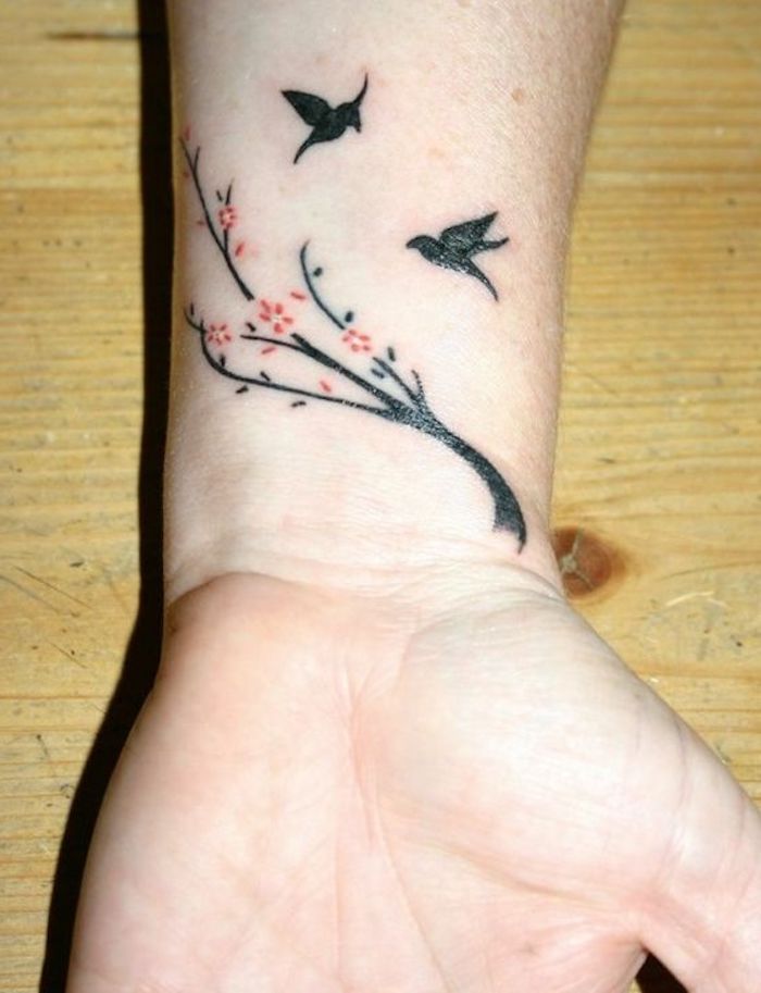 tatuajes con significado con motivos florales y animales, tatuaje en la muñeca con aves en pleno vuelo y árboles florecidos 