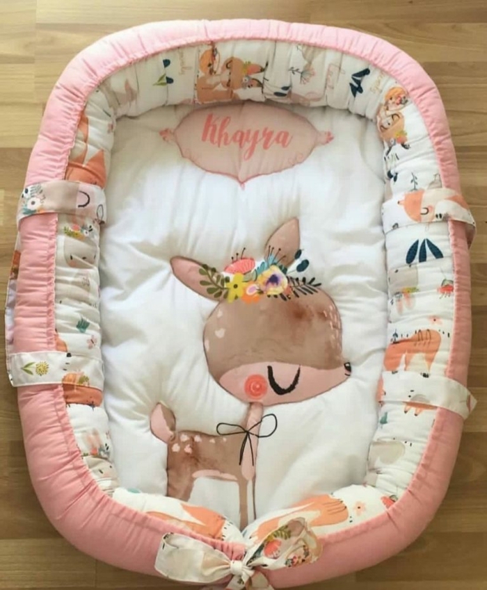  рegalos originales para recien nacidos y útiles, cama bebé bonita en color rosado con una pequeña cierva, originales ideas regalos bebé