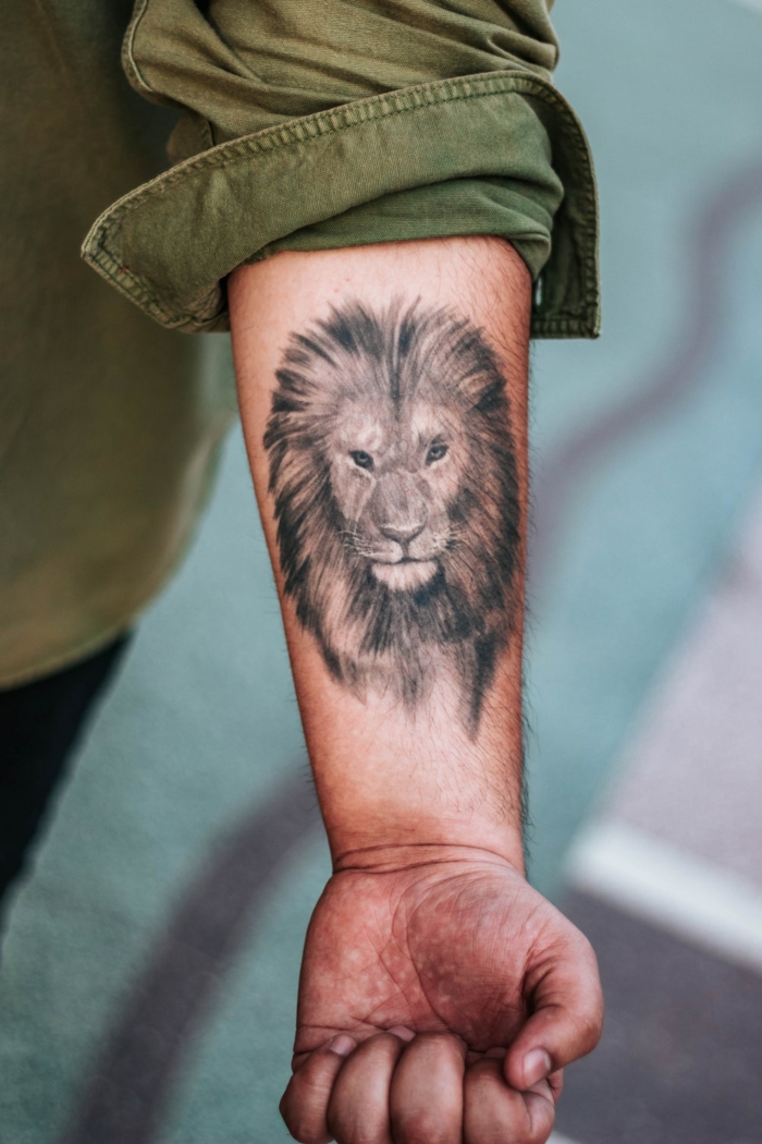 tatuaje león en estilo realista en el antebrazo, diseños de tatuajes originales con animales, tatuajes de animales significado 