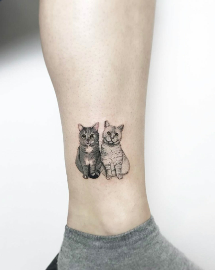 dos gatos tatuados en la pantorrilla, ideas de tatuajes originales de mascotas, diseños de tatuajes pequeños en la pierna 