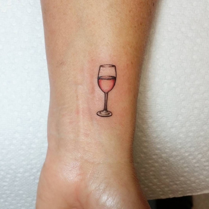 copa de vino tatuada en el antebrazo, tatuajes pequeños mujer, tatuajes simbolicos bonitos, copa de vino rosado 
