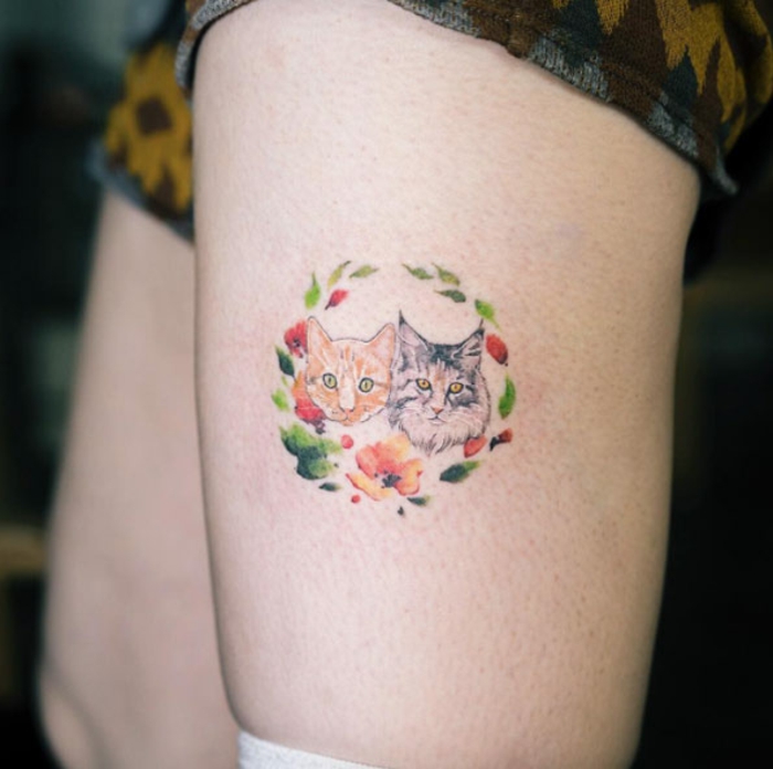bonito diseño de tatuaje en la pierna con dos gatos y corona de flores, ideas de tatuajes familia de mascotas, tatuaje colorido 