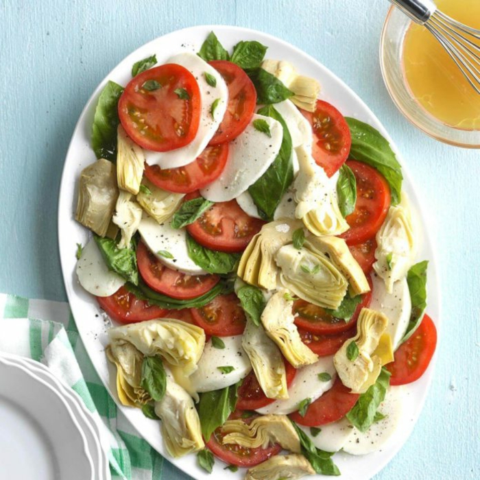 ideas de aperitivos sencillos y originales, ensalada para el verano con alcachofas, tomates, queso mozzarella y hojas de albahaca fresca 