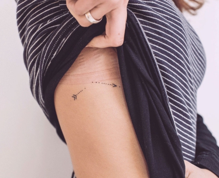 dos flechas en direcciones opuestas tatuados en los flecos, tatuajes originales con un significado escondido, pequeños tattoos 