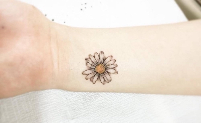 tatuajes chicos con flores, bonita margarita tatuada en el antebrazo, los mejores diseños de tatuajes pequeños para escoger 