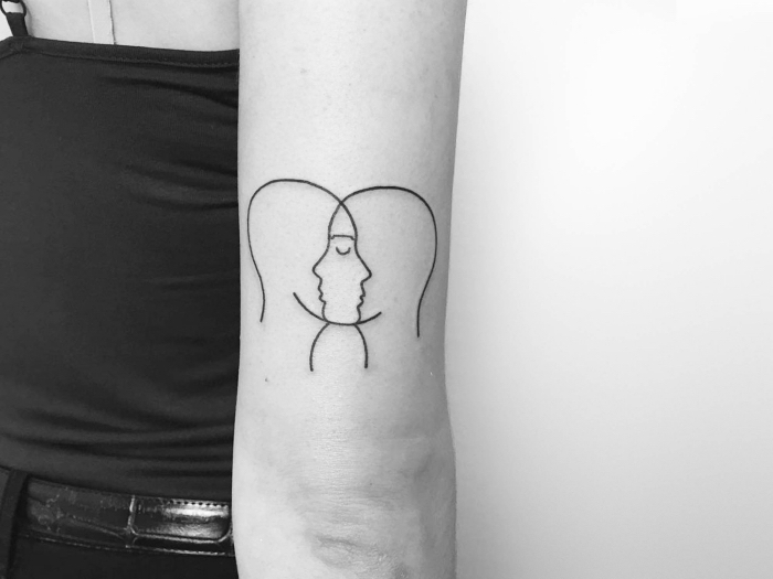 propuestas-de-tatuajes-en-el-brazo-mujer-dos-cabezas-de-hombres-pequeño-tatuaje-en-el-brazo-diseños-de-tattoos diseños simbolicos con un significado oculto, tatuaje en la parte superior del brazo, tatuajes pequeños hombre y mujer